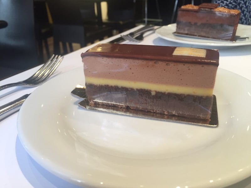 Le Bergam : chocolat noir, un biscuit cacao et un crémeux d'orange recouvert d'une mousse chocolat au lait parfumé à la Bergamote. 